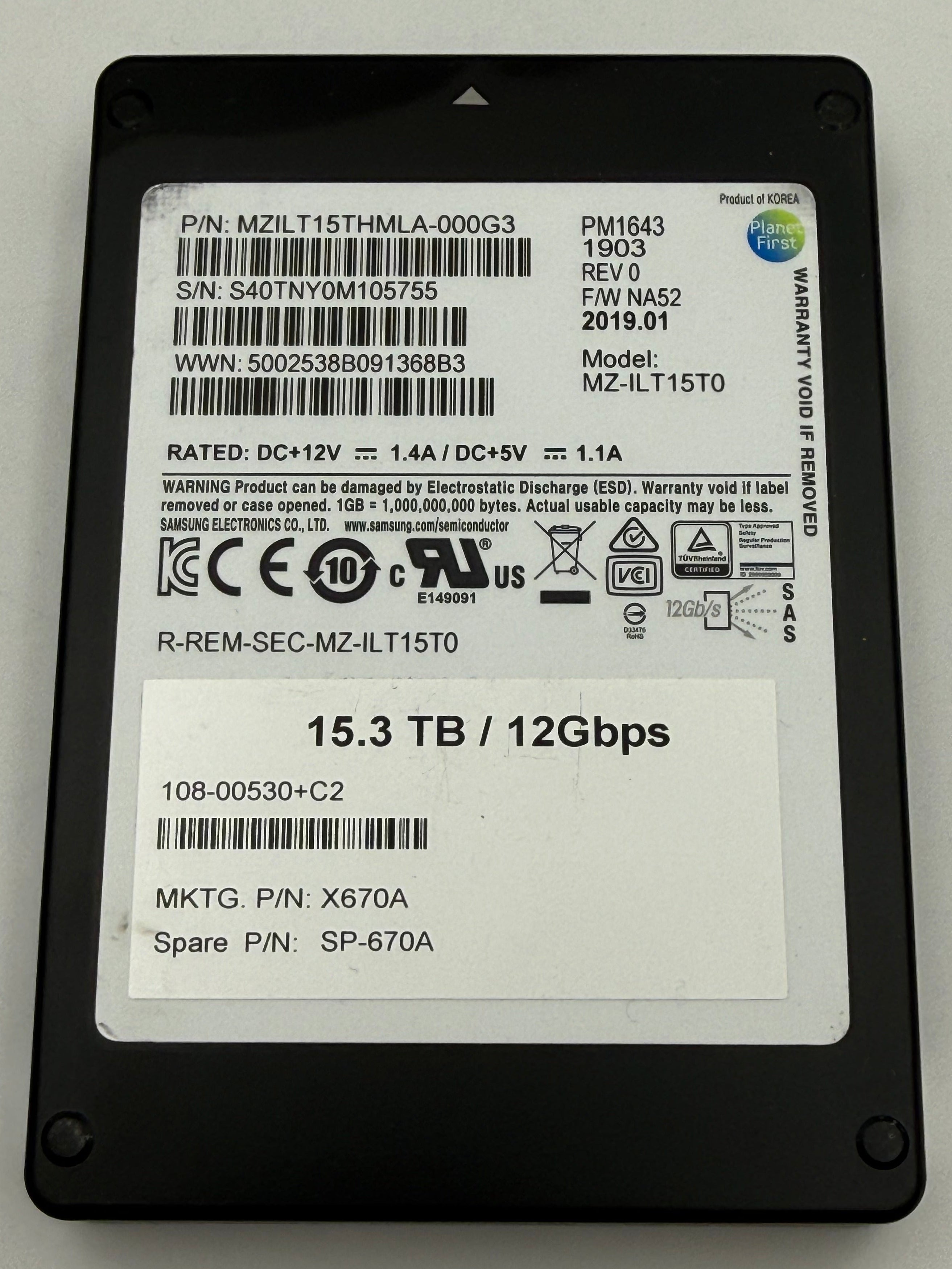 A 16x48mm 12Gbps 15.3TB solid state drive (SSD) with a black plastic casing and a white label containing barcodes and specifications.